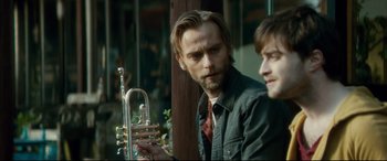 Movie still from “Horns” (2013), directed by Alexandre Aja – A man holding a trumpet while sitting next to another man; Close Up shot, Over the shoulder angle