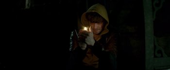 Movie still from “Horns” (2013), directed by Alexandre Aja – A man in a hooded jacket is holding a flashlight; Close Up shot, High angle