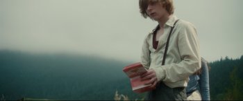 Movie still from “Horns” (2013), directed by Alexandre Aja – A man holding a book in his hands; Medium shot, Low angle