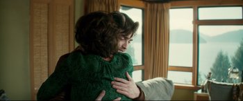 Movie still from “Horns” (2013), directed by Alexandre Aja – A woman in a green dress is hugging a man; Medium shot, Over the shoulder angle