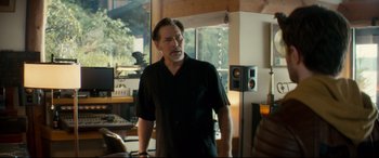 Movie still from “Horns” (2013), directed by Alexandre Aja – A man standing in front of a window in a living room; Medium shot, Over the shoulder angle