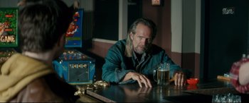 Movie still from “Horns” (2013), directed by Alexandre Aja – A man sitting at a table with a glass of beer in front of him; Medium shot, Over the shoulder angle