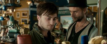 Movie still from “Horns” (2013), directed by Alexandre Aja – A man with a beard and a hat is standing next to another man in a hat; Close Up shot, Over the shoulder angle
