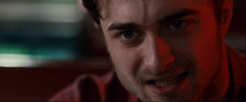 Movie still from “Horns” (2013), directed by Alexandre Aja – A man's face with a red light in the background; Extreme Close Up shot, Over the shoulder angle