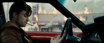 Movie still from “Horns” (2013), directed by Alexandre Aja – A person driving a red car in a city street; Medium shot, Over the shoulder angle