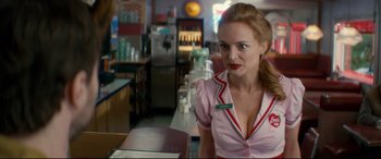 Movie still from “Horns” (2013), directed by Alexandre Aja – A woman in a pink shirt is sitting at a table; Medium shot, Over the shoulder angle