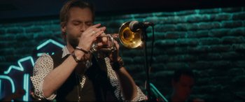 Movie still from “Horns” (2013), directed by Alexandre Aja – A man playing a trumpet in front of a microphone; Close Up shot, Low angle