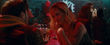 Movie still from “Horns” (2013), directed by Alexandre Aja – A woman sitting at a table in front of drinks; Close Up shot, Over the shoulder angle