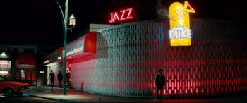Movie still from “Horns” (2013), directed by Alexandre Aja – Two people are standing in front of a building with neon lights; Extreme Wide shot, Low angle