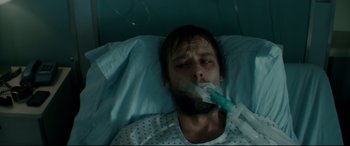 Movie still from “Horns” (2013), directed by Alexandre Aja – A man laying in a hospital bed while holding an inhaler; Close Up shot, High angle