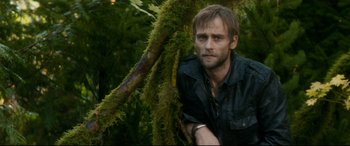 Movie still from “Horns” (2013), directed by Alexandre Aja – A man standing next to a tree in the woods; Close Up shot, Low angle