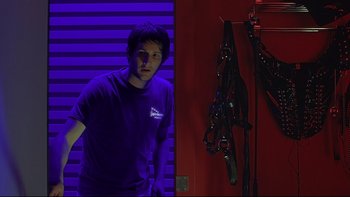 Movie still from “Hostel” (2005), directed by Eli Roth – A man standing in front of a red wall; Medium shot, Low angle