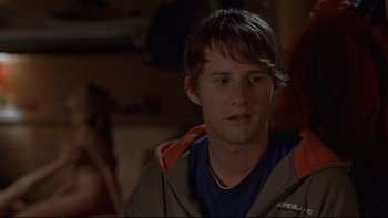 Movie still from “Hostel” (2005), directed by Eli Roth – A young man with long brown hair wearing a brown jacket; Close Up shot, Over the shoulder angle