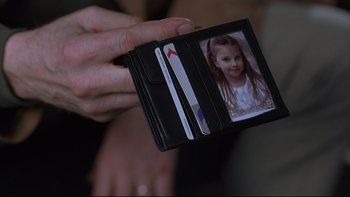 Movie still from “Hostel” (2005), directed by Eli Roth – A person holding a wallet with a picture of a child in it; Extreme Close Up shot, High angle