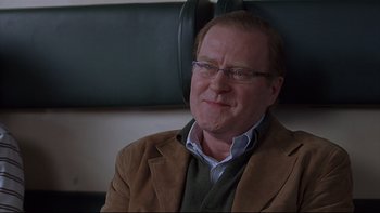 Movie still from “Hostel” (2005), directed by Eli Roth – A person sitting in a chair wearing glasses; Close Up shot, Over the shoulder angle