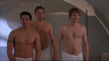 Movie still from “Hostel” (2005), directed by Eli Roth – A group of young men standing next to each other in a bathroom; Medium shot, Over the shoulder angle