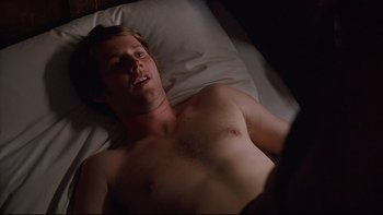 Movie still from “Hostel” (2005), directed by Eli Roth – A man laying in a bed in a dark room; Close Up shot, High angle