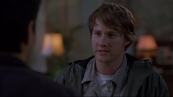 Movie still from “Hostel” (2005), directed by Eli Roth – A young man is sitting in front of a lamp; Close Up shot, Over the shoulder angle