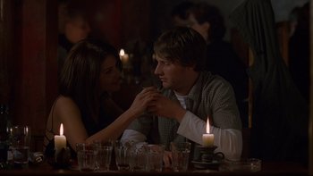Movie still from “Hostel” (2005), directed by Eli Roth – A man and a woman sitting in front of a candle; Medium shot, Over the shoulder angle