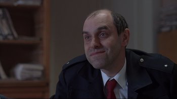 Movie still from “Hostel” (2005), directed by Eli Roth – A person wearing a suit and tie; Close Up shot, Over the shoulder angle