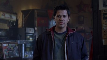Movie still from “Hostel” (2005), directed by Eli Roth – A man standing in front of a refrigerator in a room; Close Up shot, Over the shoulder angle