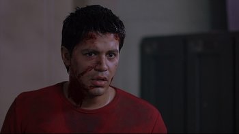 Movie still from “Hostel” (2005), directed by Eli Roth – A man with blood all over his face and head; Close Up shot, Over the shoulder angle