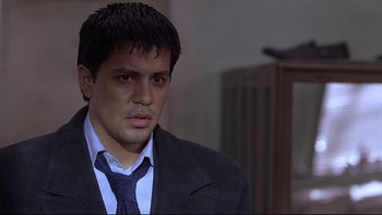 Movie still from “Hostel” (2005), directed by Eli Roth – A man wearing a suit and tie looking at the camera; Close Up shot, High angle