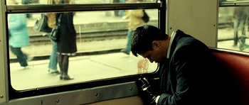 Movie still from “Hostel: Part II” (2007), directed by Eli Roth – A man sitting on a train looking out of the window; Medium shot, High angle