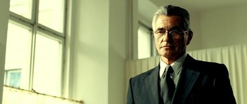 Movie still from “Hostel: Part II” (2007), directed by Eli Roth – An older man wearing a suit and tie; Close Up shot, Low angle