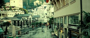 Movie still from “Hostel: Part II” (2007), directed by Eli Roth – People walking down a street on a rainy day; Extreme Wide shot, High angle