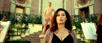 Movie still from “Hostel: Part II” (2007), directed by Eli Roth – A woman standing in front of a naked man on steps; Medium shot, Over the shoulder angle