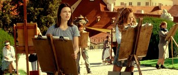 Movie still from “Hostel: Part II” (2007), directed by Eli Roth – A group of people standing in front of a building; Medium shot, Over the shoulder angle