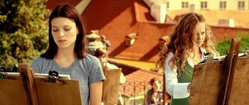 Movie still from “Hostel: Part II” (2007), directed by Eli Roth – Two young women standing next to each other on a sunny day; Medium shot, Over the shoulder angle