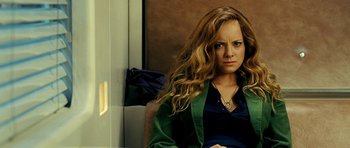Movie still from “Hostel: Part II” (2007), directed by Eli Roth – A woman sitting in front of a window with long blonde hair; Close Up shot, Over the shoulder angle