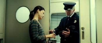 Movie still from “Hostel: Part II” (2007), directed by Eli Roth – A man in a uniform and a woman on a train; Medium shot, Low angle