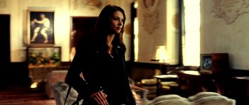 Movie still from “Hostel: Part II” (2007), directed by Eli Roth – A woman in a black jacket holding a black purse; Medium shot, Low angle