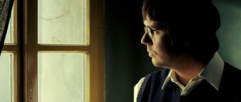 Movie still from “Hostel: Part II” (2007), directed by Eli Roth – A man wearing glasses looking out a window; Close Up shot, Over the shoulder angle