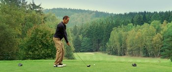Movie still from “Hostel: Part II” (2007), directed by Eli Roth – A man is playing golf on a golf course; Wide shot, High angle