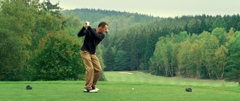 Movie still from “Hostel: Part II” (2007), directed by Eli Roth – A man swinging a golf club on a golf course; Wide shot, Low angle