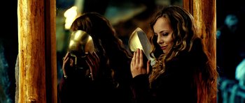 Movie still from “Hostel: Part II” (2007), directed by Eli Roth – A woman holding a pair of golden masks; Close Up shot, Over the shoulder angle