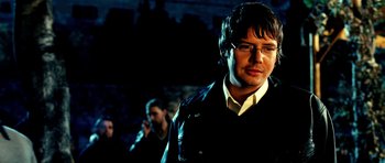 Movie still from “Hostel: Part II” (2007), directed by Eli Roth – A man with glasses and a black jacket; Close Up shot, Over the shoulder angle