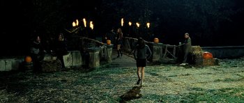 Movie still from “Hostel: Part II” (2007), directed by Eli Roth – A group of people walking across a bridge at night; Wide shot, High angle