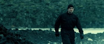 Movie still from “Hostel: Part II” (2007), directed by Eli Roth – A man in a black jacket is walking in the snow; Medium shot, Low angle