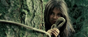 Movie still from “Hostel: Part II” (2007), directed by Eli Roth – A woman holding a rope around a tree trunk; Close Up shot, Low angle
