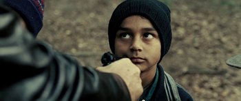 Movie still from “Hostel: Part II” (2007), directed by Eli Roth – A young man holding a gun up to his face; Close Up shot, Over the shoulder angle