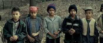 Movie still from “Hostel: Part II” (2007), directed by Eli Roth – A group of young people standing next to each other in the woods; Medium shot, High angle