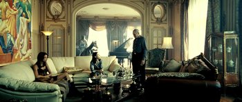 Movie still from “Hostel: Part II” (2007), directed by Eli Roth – A man and a woman are sitting in a living room; Wide shot, High angle