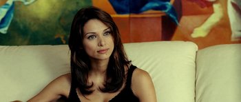 Movie still from “Hostel: Part II” (2007), directed by Eli Roth – A beautiful woman sitting on a couch in a room; Close Up shot, High angle