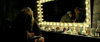Movie still from “Hostel: Part II” (2007), directed by Eli Roth – A woman sitting in front of a mirror in a dressing room; Medium shot, Over the shoulder angle