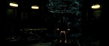 Movie still from “Hostel: Part II” (2007), directed by Eli Roth – A person sitting on a chair in a dark room; Wide shot, High angle